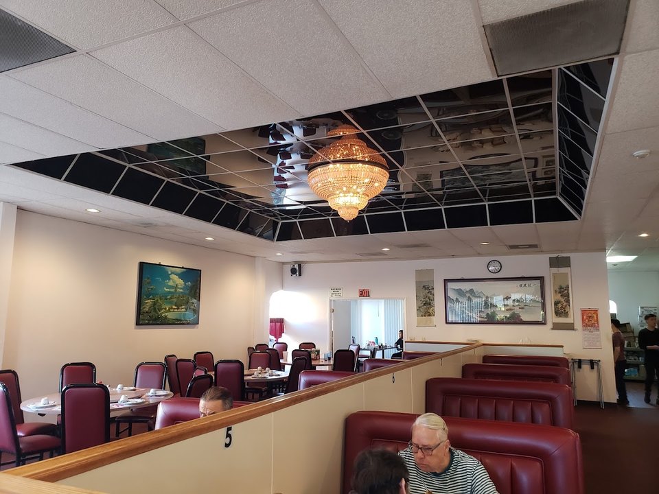 Booth-lined Chinese dining room with simple tables.